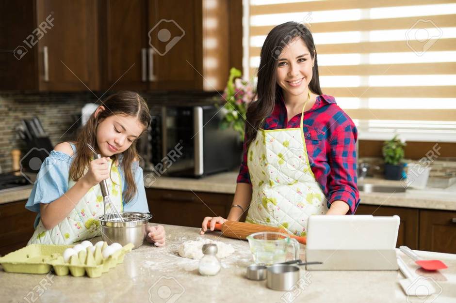 Мама готовит пирог. Мама с дочкой готовят. Дочка готовит. Мама и две девочки готовят.